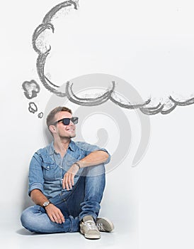 Young caucasian man wear sunglasses while sitting on the floor t
