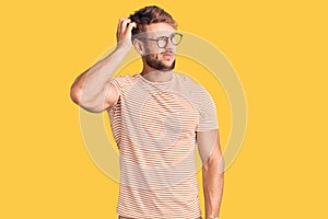 Young caucasian man wearing casual clothes and glasses confuse and wondering about question