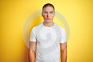 Young caucasian man wearing casual white t-shirt over yellow isolated background depressed and worry for distress, crying angry