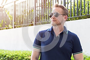 Young caucasian man wearing sunglasses relaxing in outdoor