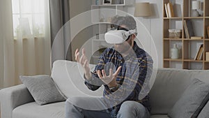 Young caucasian man wearing vr glasses play games at home in the living room