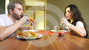 Young caucasian man and woman drinking carbonated soft drink and mineral water. Junk food versus healthy eating concept