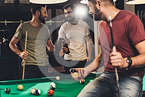 young caucasian men drinking beer beside billiard table photo