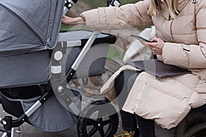 young caucasian mother walking with newborn baby in buggy due to coronavirus covid-19 pandemic lockdown. Business woman