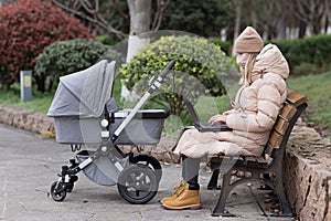 young caucasian mother walking with newborn baby in buggy due to coronavirus covid-19 pandemic lockdown. Business woman