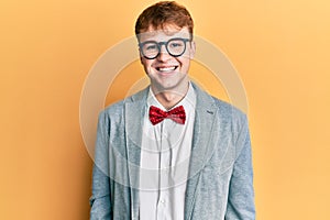 Young caucasian nerd man wearing glasses wearing hipster elegant look with bowtie looking positive and happy standing and smiling