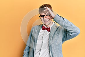 Young caucasian nerd man wearing glasses wearing hipster elegant look with bowtie smiling happy doing ok sign with hand on eye