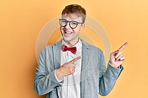 Young caucasian nerd man wearing glasses wearing hipster elegant look with bowtie smiling and looking at the camera pointing with