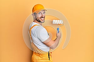 Young caucasian painter smiling happy painting wall using roller