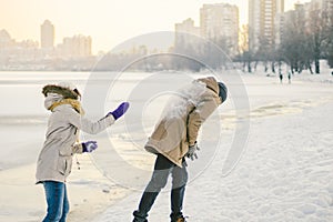 Young Caucasian people in love heterosexual couple have a date in winter near a frozen lake. Active holiday holiday Valentine`s