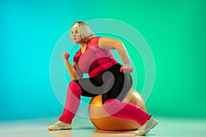 Young caucasian plus size female model`s training on gradient green background