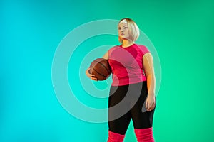 Young caucasian plus size female model`s training on gradient green background