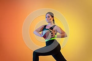 Young caucasian plus size female model`s training on gradient orange background