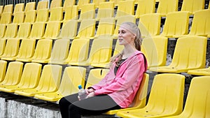 young caucasian pretty girl laughing outdoors after workout or fitness training