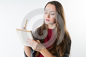 Young caucasian pretty girl with sketchbook and pencil on white background