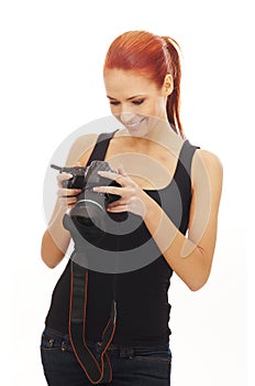 A young Caucasian redhead woman holding a camera