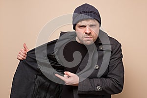 Young caucasian speculator man pointing on his coat on empty place hiding deficit food