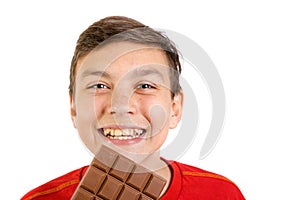 Young caucasian teenage boy with a bar of chocolate