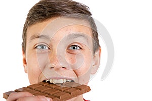 Young caucasian teenage boy with a bar of chocolate