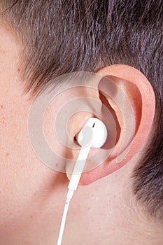 Young caucasian teenage boy`s ear and headphone