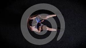 Young caucasian topless boxer doing abdominal exercise, boxing, top shot, black background. 50 fps