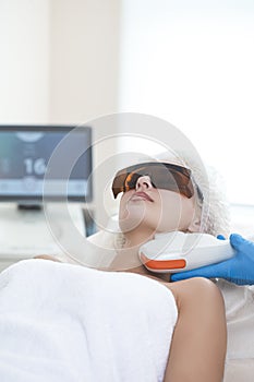 Young Caucasian Winsome Woman Getting IPL Laser and Ultrasound Facial Treatment in Modern Medical Spa Center