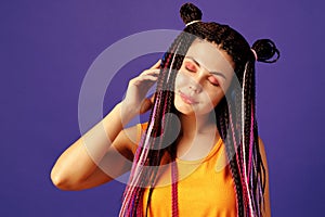 Young caucasian woman with african cornrows listening to music with headphones