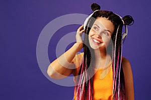 Young caucasian woman with african cornrows listening to music with headphones