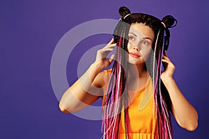 Young caucasian woman with african cornrows listening to music with headphones