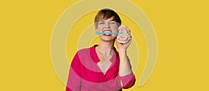 A young Caucasian woman with an amazing smile with a toothbrush in her hands on a yellow isolated background. Plastic