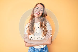 Young caucasian woman with blond hair wearing casual summer clothes happy face smiling with crossed arms looking at the camera