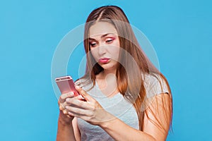Young caucasian woman read the phone message with incredulous grimace photo