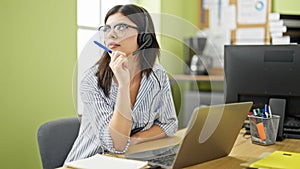 Young caucasian woman business worker using laptop and headphones thinking at office