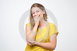 Young caucasian woman closing her mouth and wide open eye isolated on white background.