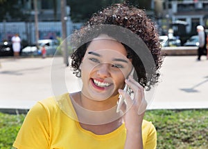 Young caucasian woman with curly hair speaking at mobile phone