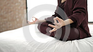 Young caucasian woman doing yoga posture sitting on bed at bedroom