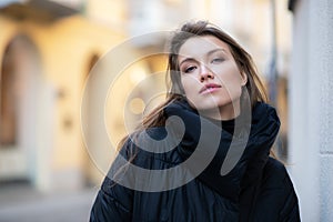 Young caucasian woman dressed in black clothes. Beautiful caucasian girl posing outdoor in Milan, Italy. Street fashion, winter