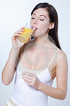Young caucasian woman drinking orange juice
