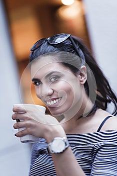 Young caucasian woman drinks coffee