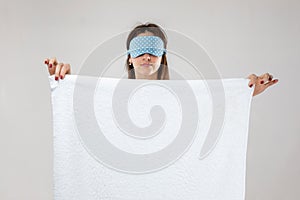 Young caucasian woman in eyemask holding towel photo
