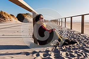 Young caucasian woman with eyes closed relaxing at the beach at sunset. Holidays and relaxation concept