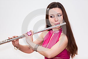 Young Caucasian woman flutist playing on flute, photo