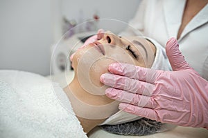 young caucasian woman getting facial spa massage at spa salon