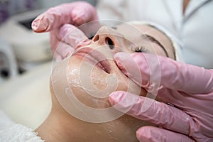 young caucasian woman getting facial spa massage at spa salon