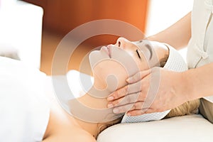 A young Caucasian woman getting a head massage It`s in a spa shop. Yougn Caucasian girl relaxing with hand spa massage at beauty