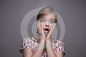 Young caucasian woman girl surprised, scared, shocked; `Oh my God!`