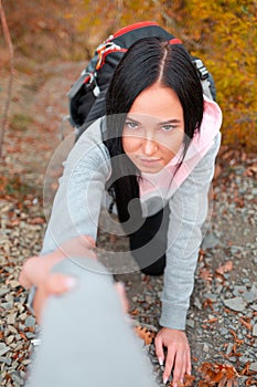 A young Caucasian woman grabs her friend`s helping hand. Concept of Hiking and assistance