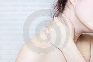 Young caucasian woman with hand on her unhealthy neck and shoulder. Self massage, office syndrome, neck ache and musclar pain