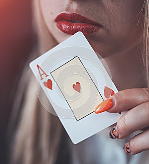 Young caucasian woman holding aces close up near red lips