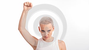 Young caucasian woman holding her fist up on a white background. A girl with short hair is fighting for rights